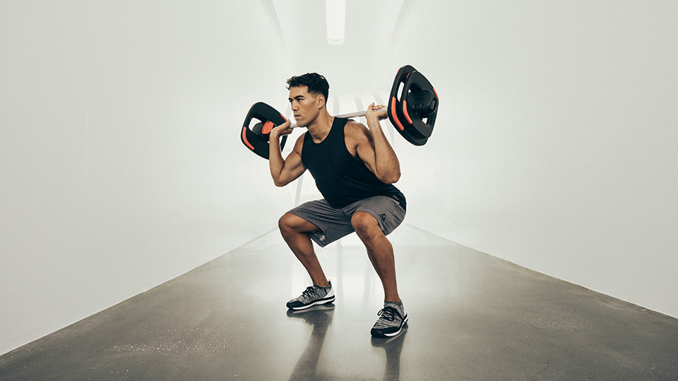 Squat with a Les Mills SMARTBAR weight plate to create hypertrophy