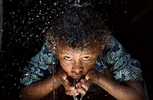 Happy child drinking fresh water